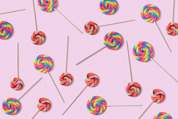 Colorful lollipop pattern. Candies with stick isolated on pink background. Flat lay. Party, sale, discount background