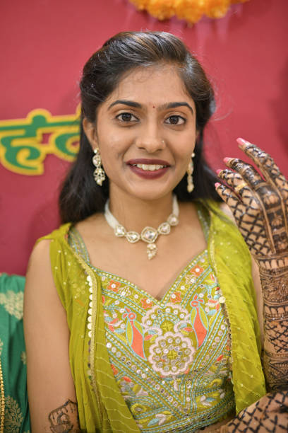 istock Bride in her modern traditional attire displaying her Mehandi, looking at camera 2169051560