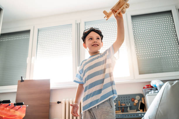 istock Joyful Boy Playing Pilot in His Room 2169057452