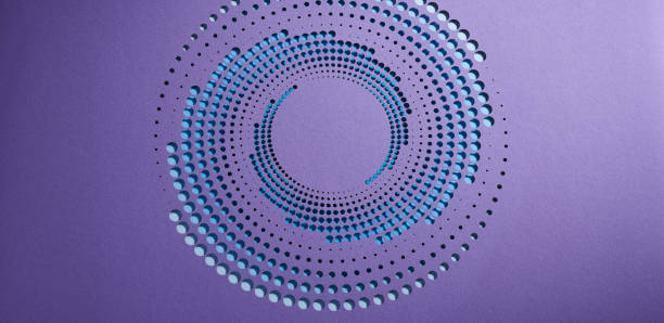 Native image size: 7952 x 4473. An intricate pattern of circular cut-outs in varying sizes forms a spiral on a deep purple background. The gradient from light blue to black creates a dynamic visual effect, highlighting the depth and precision of the paper art. The design draws the eye toward the center, evoking a sense of movement and sophistication.