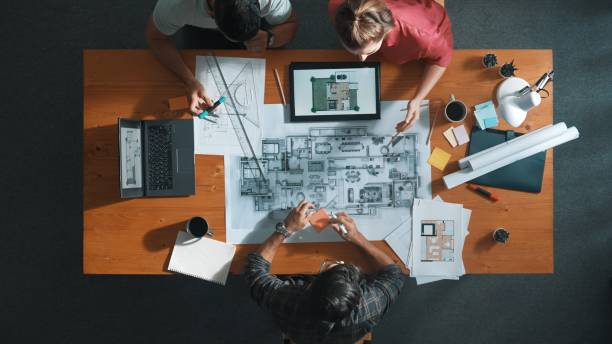 istock Top down view of engineer handed document while looking at blueprint. Symposium. 2169060811