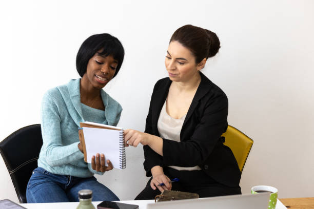 istock Two businesswomen having a productive meeting discussing notes in a notebook 2169064832