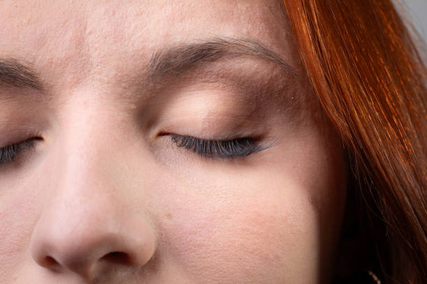 Redhead woman is closing her eyes, showing her makeup
