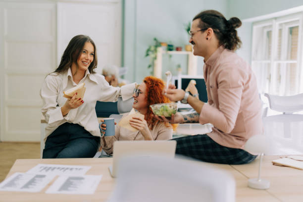 istock Happy colleagues having a lunch break in an office 2169065692
