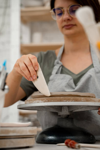 istock Crafting smooth angle conversion and textured ribs with a clay pottery scrapper. Girl is using a pottery scrapper to smooth the edges of a clay product. 2169067850
