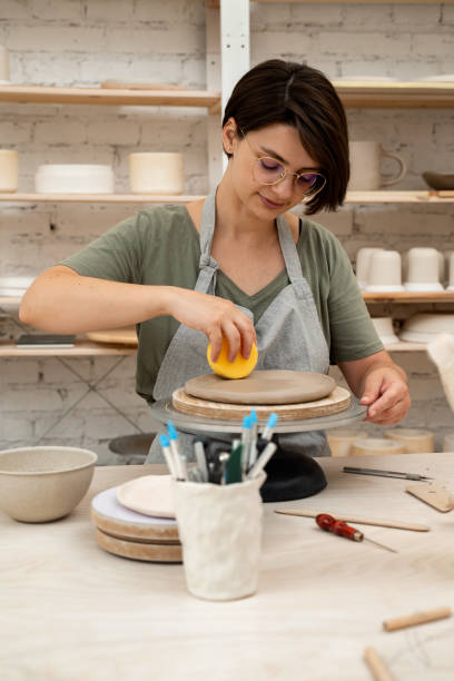 istock Using sponge for pottery class. Absorbing sponge to get rid of excess moisture. Applying more moisture on clay products. Smoothing clay with a sponge. Ceramics workshop. 2169068022