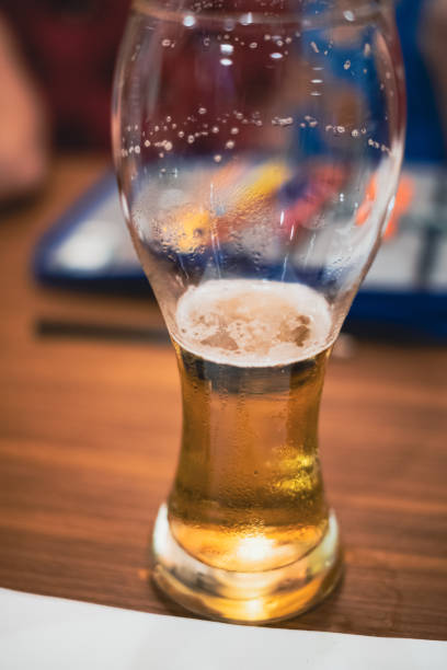 istock Half beer on a drinking glass in a wooden table close up 2169070574