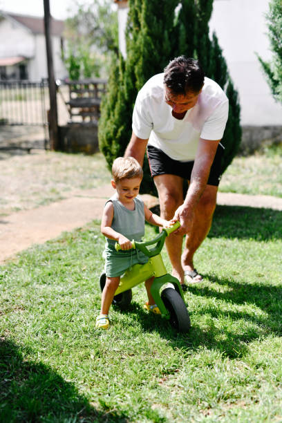 istock Double Enjoyment For Toddler And Grandpa During First Backyard Bicycle Riding Lesson 2169071609