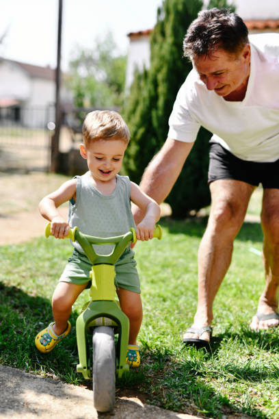 istock Toddler Getting Help From Grandpa While Learning To Ride Bicycle 2169071985