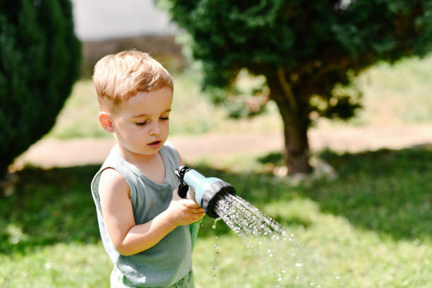 istock Toddler Playing With Spray Nozzle In Backyard 2169072040