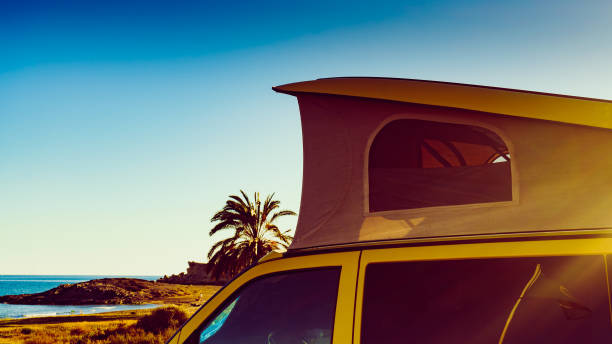 istock Camper van with tent on roof on beach 2169074413