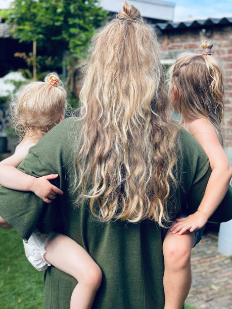 Young mother with her children in rear view