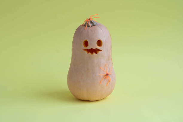 istock Smiling pumpkin with a spider on Halloween on a yellow background. 2169078091