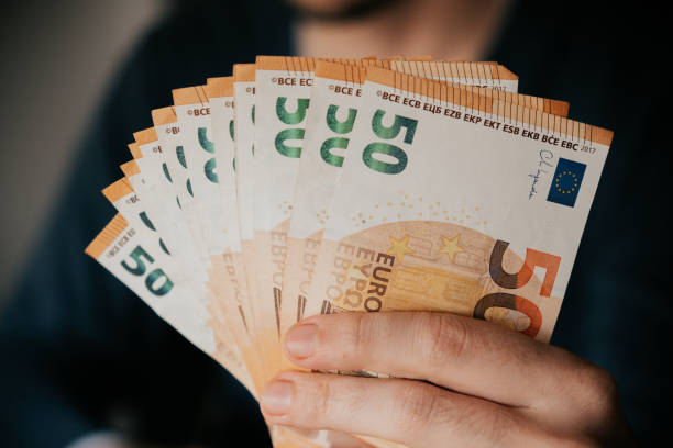 istock Man holding euro banknotes in his hand. Close-up. 2169082189