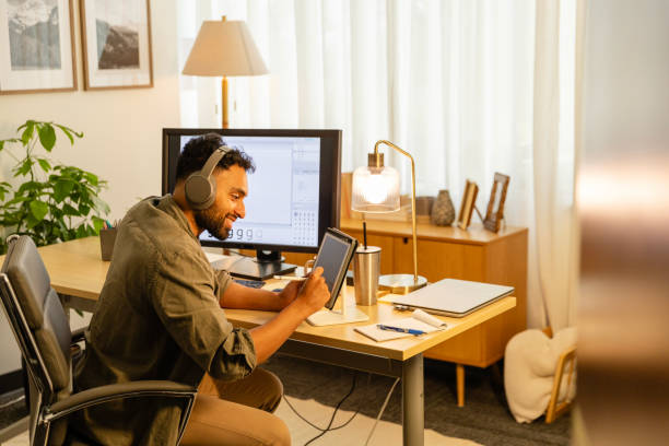 istock Young adult man uses tablet and desktop PC for project 2169088391