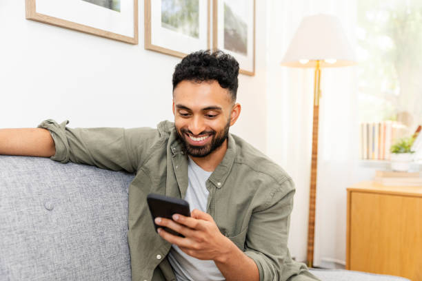 istock Man sits on sofa in office to relax on phone 2169088405