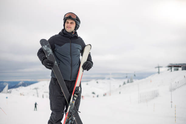 istock Man standing with skis against snowy mountain view. 2169102427