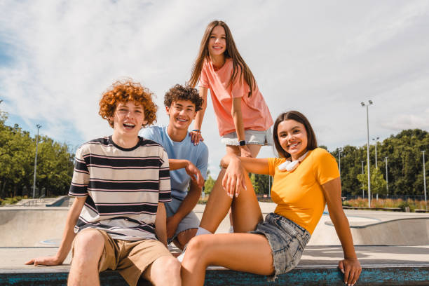 Photo of happy teenagers spending summer holiday having fun meeting hanging out outside stock photo