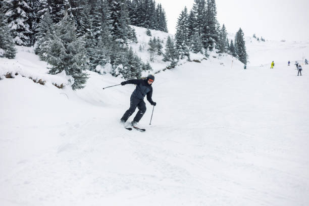 istock Alpine skier skiing swiftly down the snowy mountain. 2169102635
