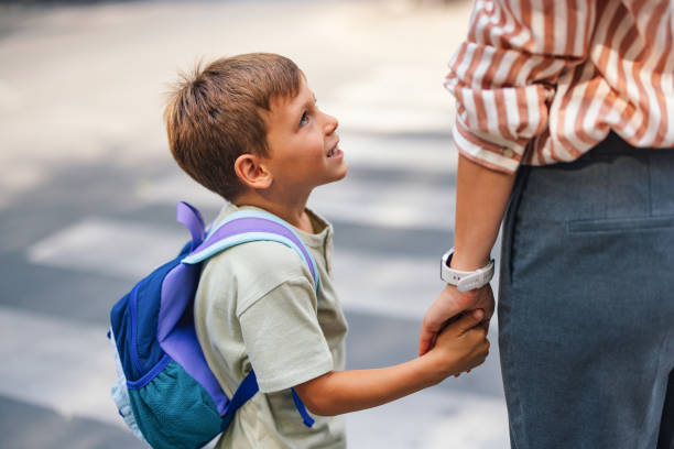 istock Mom and Son Holding Hands on Back to School Day 2169109455