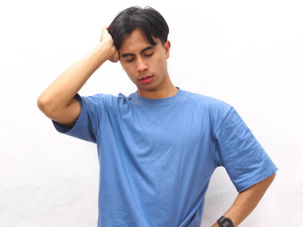 istock Stressed young Asian man wearing blue t-shirt posing on white background. 2169123741
