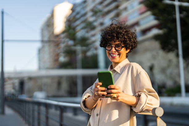 istock Joyful Woman Enjoying Smartphone Connectivity in Urban Setting 2169132324