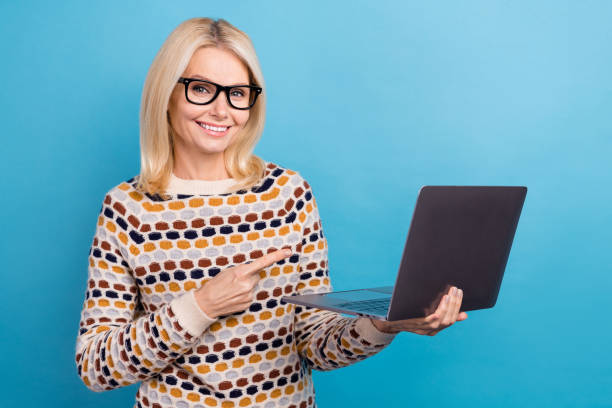 Photo of cheerful clever lady dressed pullover eyewear pointing apple samsung device empty space isolated blue color background