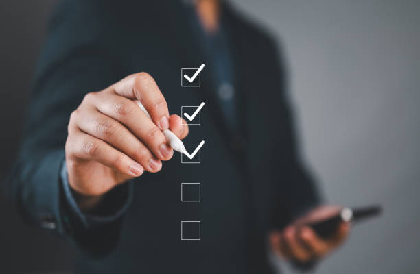 istock Businessman use pen to tick correct sign mark in checkbox for quality document control checklist and business approve project concept. 2169141497