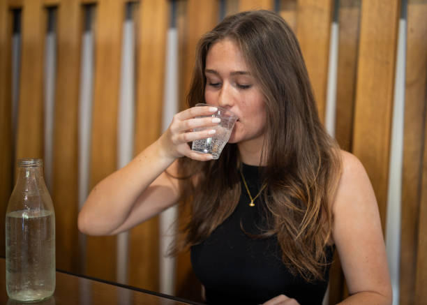 istock Female drinking still or sparkling water from a glass cup in a cafe. 2169142307