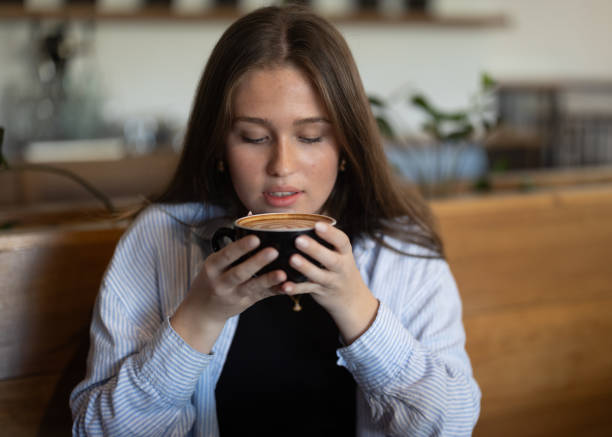 istock Female drinking mug of coffee at a cafe. 2169142353