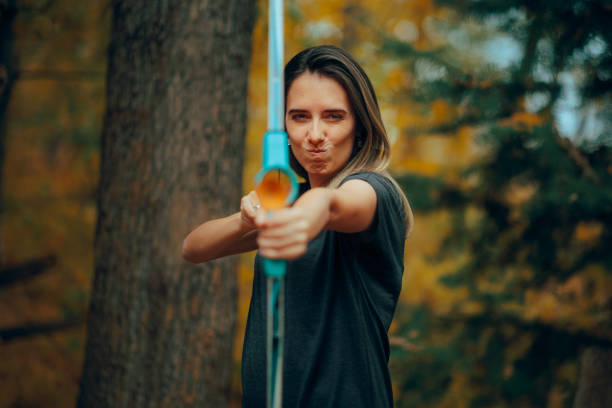 Concentrated sporty lady trying to aim afar squinting her eyes