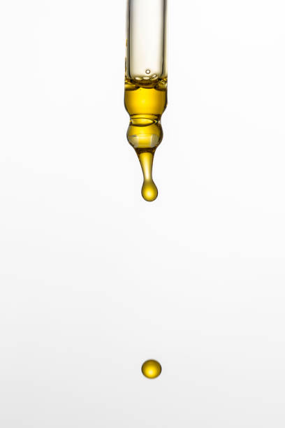 istock Dripping cosmetic serum from pipette on white background. Face serum 2169150100