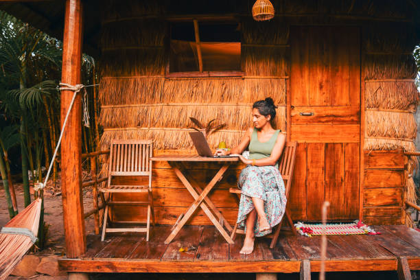 istock Close up young caucasian hipster woman sit use computer freelance do freelancing work, write travel blog or browse internet search, work online while traveling in southeast asia tropical islands 2169167541