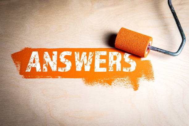 istock Answers. Orange paint and paint roller on wood texture background 2169169577