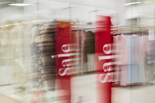 Entrance of clothes shop with red sale banners in local popular store