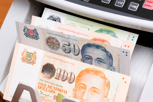 istock Singapore dollar in the counting machine 2169171538