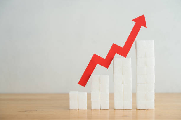 istock Red arrow graph rising trend on stack growth sugar cubes with white wall background copy space. 2169171951