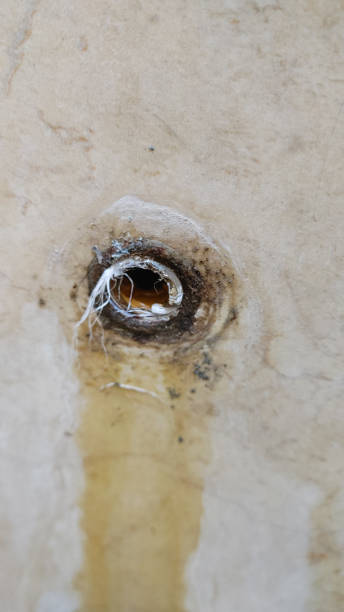istock broken pipe on the tile wall in the bathroom. Water drip marks make the wall yellow. View of the old broken faucet before repair 2169173291
