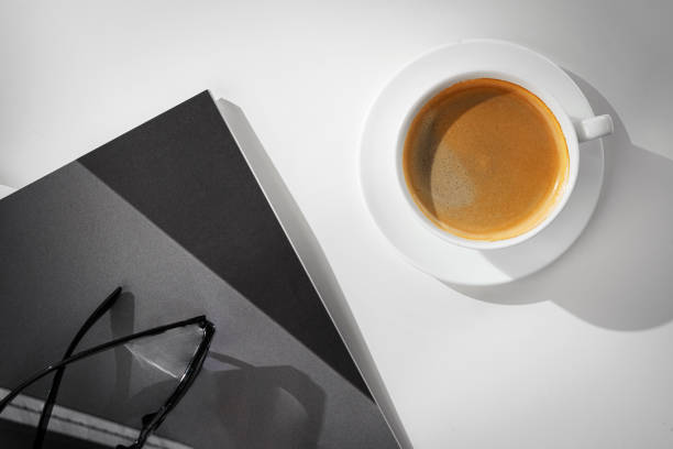 istock A Cup of Coffee, Glasses, and a Stack of Magazines on a White Tabletop 2169177317