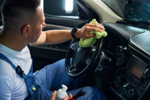 istock Worker cleans the steering wheel of car with soft cloth 2169181664
