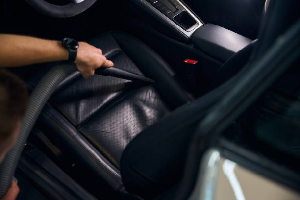 istock Man cleans a car with vacuum cleaner with crevice nozzle 2169181667