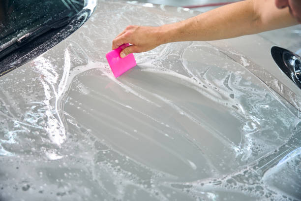 istock Man uses a special spatula to apply a protective film 2169181818