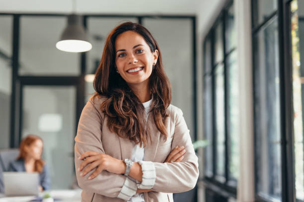 istock Smiling businesswoman standing confidently in modern office space. 2169186474
