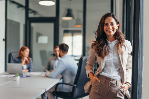 istock Smiling businesswoman standing confidently in modern office space. 2169186488
