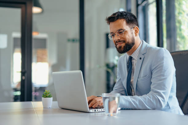istock Happy businessman working on laptop in the office 2169186501