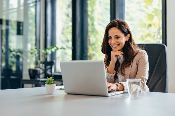 istock Professional woman at desk using laptop and sitting in modern office. 2169188623