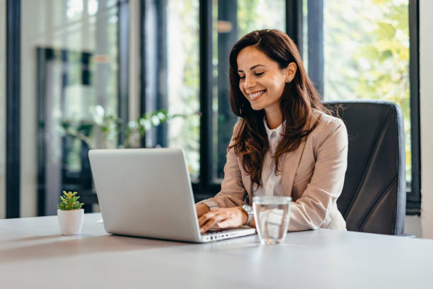 istock Professional woman at desk using laptop and sitting in modern office. 2169188841