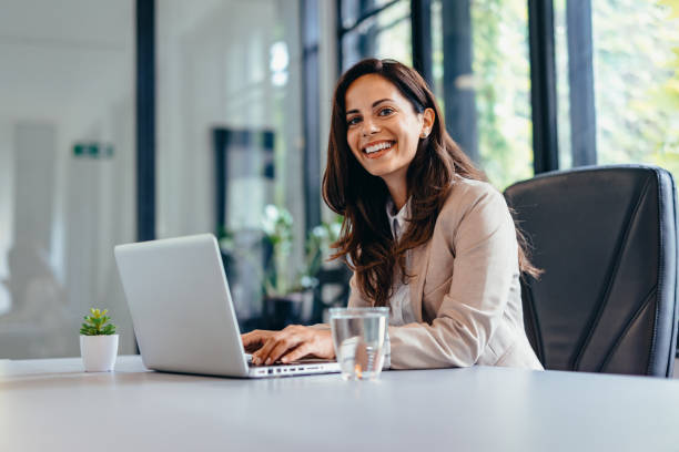 istock Professional woman at desk using laptop and sitting in modern office. 2169189044