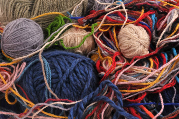 Mix of balls of wool and pieces of wool closeup on background