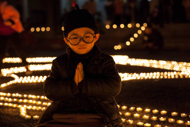A young Asian boy is praying for blessings in a temple